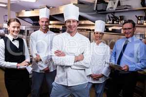 Happy restaurant team standing together in commercial kitchen