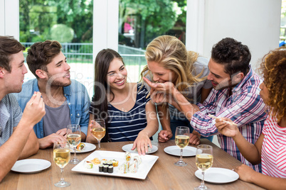 Friends enjoying wine and sushi at home