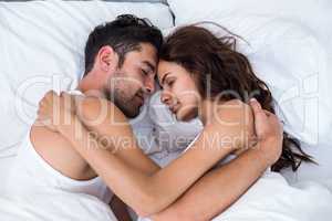 Couple relaxing on bed in bedroom