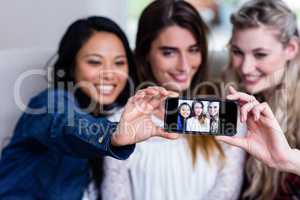 Young female friends taking selfie with mobile phone