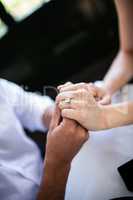 Close-up of couple holding hands with engagement ring