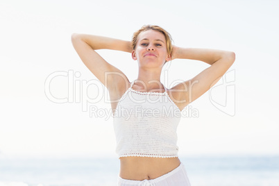 Portrait of beautiful woman stretching her arms on the beach