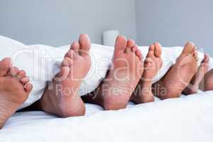 Feet of family sticking out from the quilt