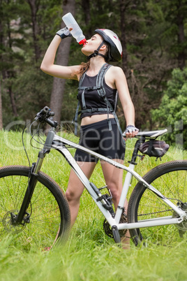 Woman drinking water next to her bike