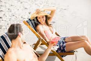 Young couple sitting on armchair with cocktail drink