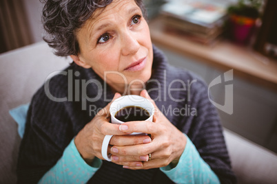 Thoughtful mature woman holding coffee cup