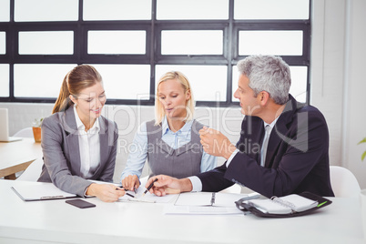 Business people discussing with client over documents