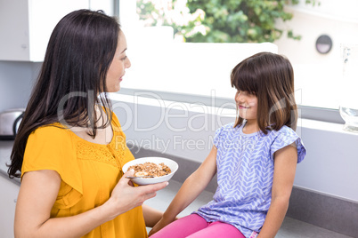 Mother feeding breakfast to her daughter