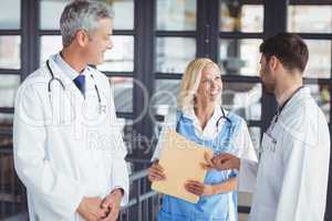 Male doctor giving document to coworker