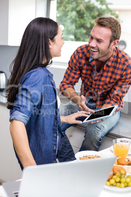 Couple interacting using laptop and digital tablet