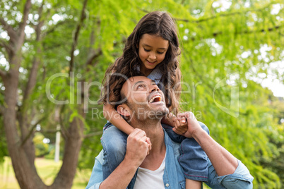 Father carrying daughter on his shoulders