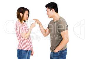 Young couple pointing at each other while having an argument