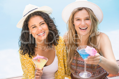 Young women having martini near pool