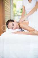 Masseur massaging beautiful woman at health spa