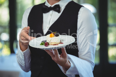Waitress holding a plate with dessert
