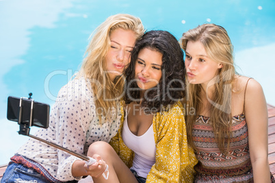 Beautiful women taking a selfie by swimming pool