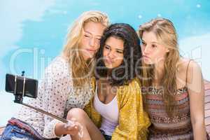 Beautiful women taking a selfie by swimming pool