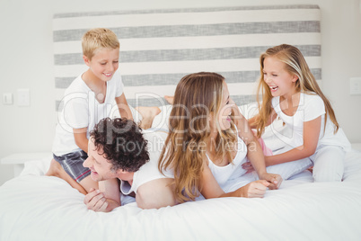 Playful family on bed at home