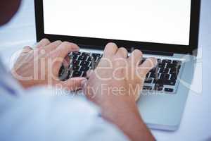 Close up of masculine hands typing on laptop