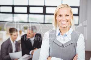 Happy businesswoman with business people in background