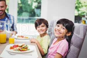 Smiling children sitting at dining table