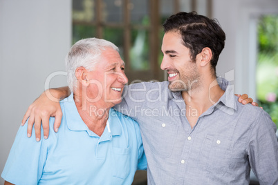 Smiling father and son with arm around