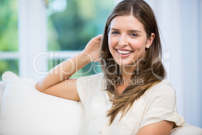 Portrait of happy woman sitting on sofa