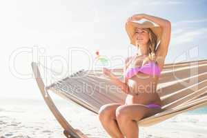 Woman drinking cocktail in hammock