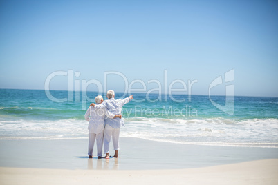 Senior couple embracing and pointing