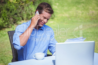 Handsome businessman on the phone reading a document