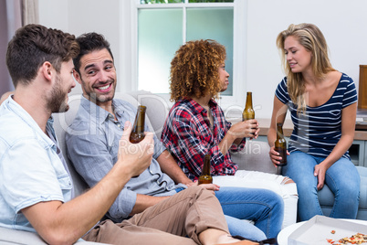 Multi-ethnic friends smiling while enjoying beer