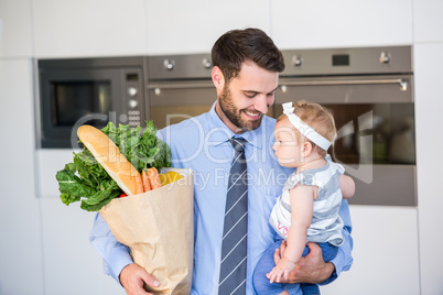 Businessman carrying vegetables and daughter