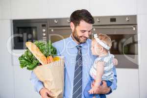 Businessman carrying vegetables and daughter