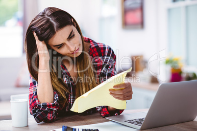 Frustrated young woman holding document