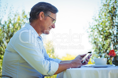 Casual mature businessman using smartphone