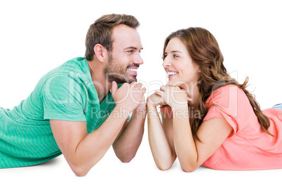 Happy young couple lying on floor looking to each other