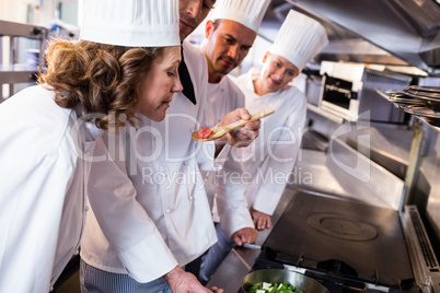 Head chef showing food to his colleagues