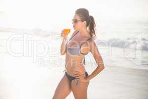 Glamorous woman having a cocktail drink on the beach