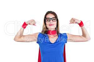Portrait of smiling woman in superhero costume while flexing mus