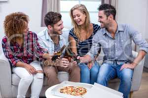 Cheerful friends enjoying beer and pizza