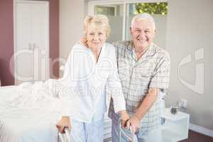Portrait of senior smiling couple with walker