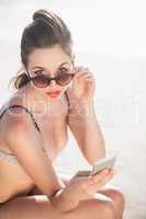 Glamorous woman in bikini looking over sunglasses