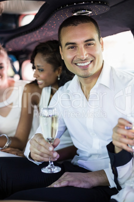 Well dressed man drinking champagne in a limousine