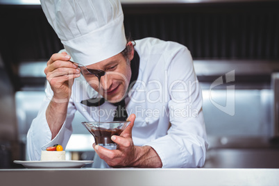 Chef putting chocolate sauce on a dessert