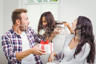 Mother looking at daughter surprising father