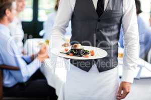 Waiter holding a plate of meal