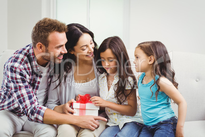 Happy parents with daughters holding gift