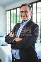 Smiling businessman posing with crossed arms