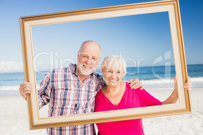 Senior couple holding frame