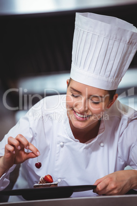 Chef putting a cherry on a dessert